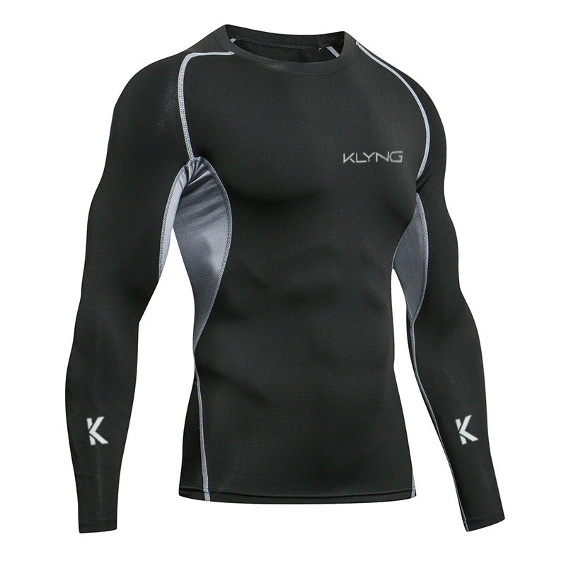 A black long-sleeve athletic shirt with gray accents and the logo KLYNG on the chest and sleeves. The shirt features a fitted design, highlighting muscle definition.