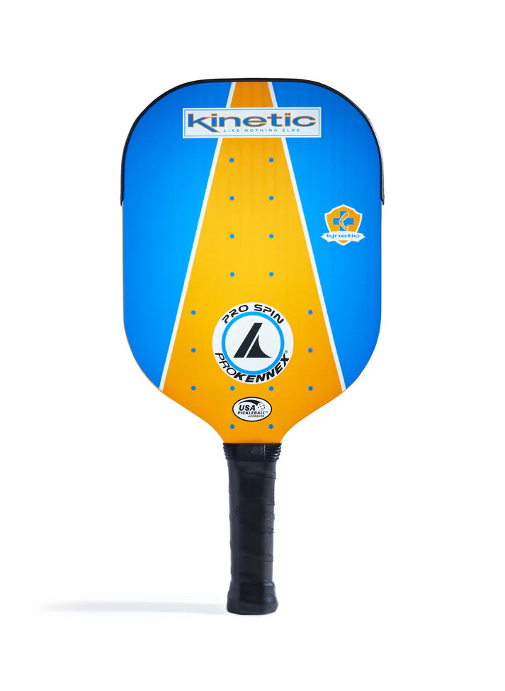 The Prokennex Pro Spin Pickleball Paddle showcases a blue and orange design with the kinetic logo at the top and a prominent "Pro Spin" and "Prokennex" branding in the center. It features a black grip crafted for maximum spin, along with the USA Pickleball approval logo prominently displayed.