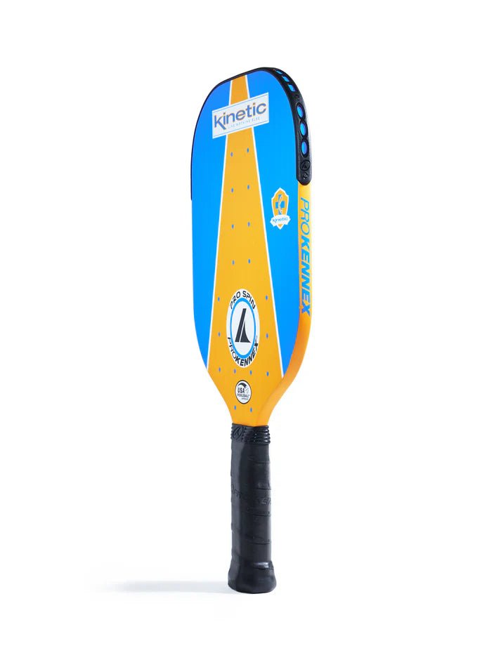 The Prokennex Pro Spin Pickleball Paddle showcases a vibrant blue and orange design adorned with logos and the text "Kinetic" and "ProKennex." It features a Kinetic system for optimal spin and includes a black grip handle. The paddle is displayed upright against a white background.