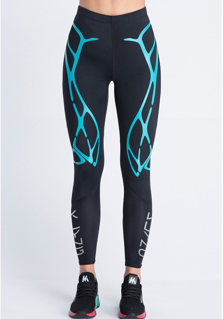 A person wearing Klyng's Women’s PowerFlex Pickleball Compression Pants in a black design featuring blue abstract patterns stands against a plain white background. They are also sporting black athletic shoes with pink and teal soles, utilizing advanced CourtTech Technology for enhanced muscle support.