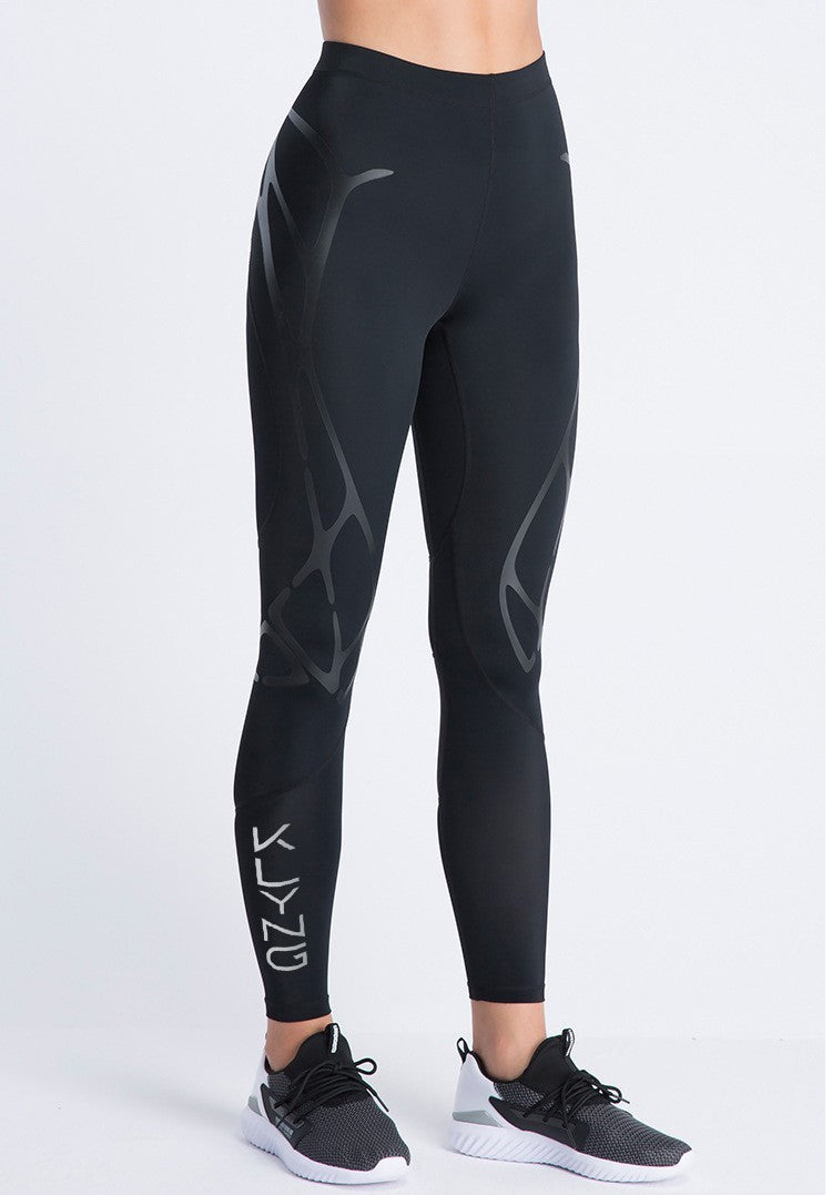 A person is wearing black leggings with abstract designs and white sneakers, standing against a plain white background. The word Klyng is printed on the lower left side of these Women’s PowerFlex Pickleball Compression Pants, designed for enhanced muscle support to boost performance and comfort.