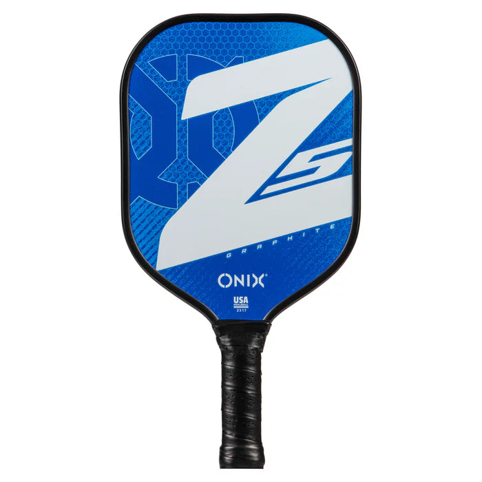 A close-up shot of the Graphite Z5 v3 Pickleball Paddle shows its distinct features, including a black grip and a striking blue face. The paddle has a tennis handle shape designed for optimal control. Its surface is adorned with a large white “Z” alongside hexagonal patterns, with the brand name “Onix” and "USA" displayed near the handle.