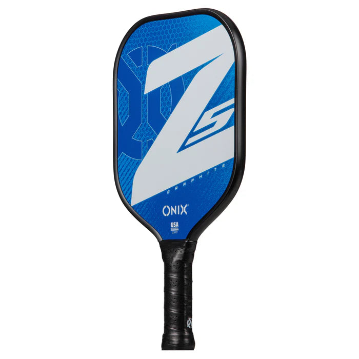 A close-up of the Graphite Z5 v3 Pickleball Paddle showcases a blue and white design with a prominent Z on the face and the Onix brand name near the handle. The paddle, resembling a tennis handle shape, is wrapped in black material to provide optimal grip.