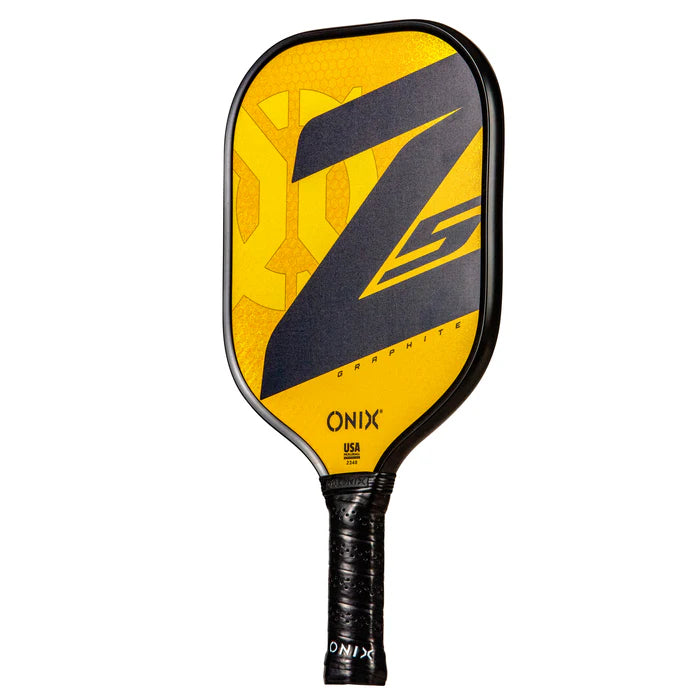 The Onix Graphite Z5 v3 Pickleball Paddle is yellow and black, featuring the printed words "ONIX" and "Graphite Z5." It has a tennis handle shape with a textured grip.